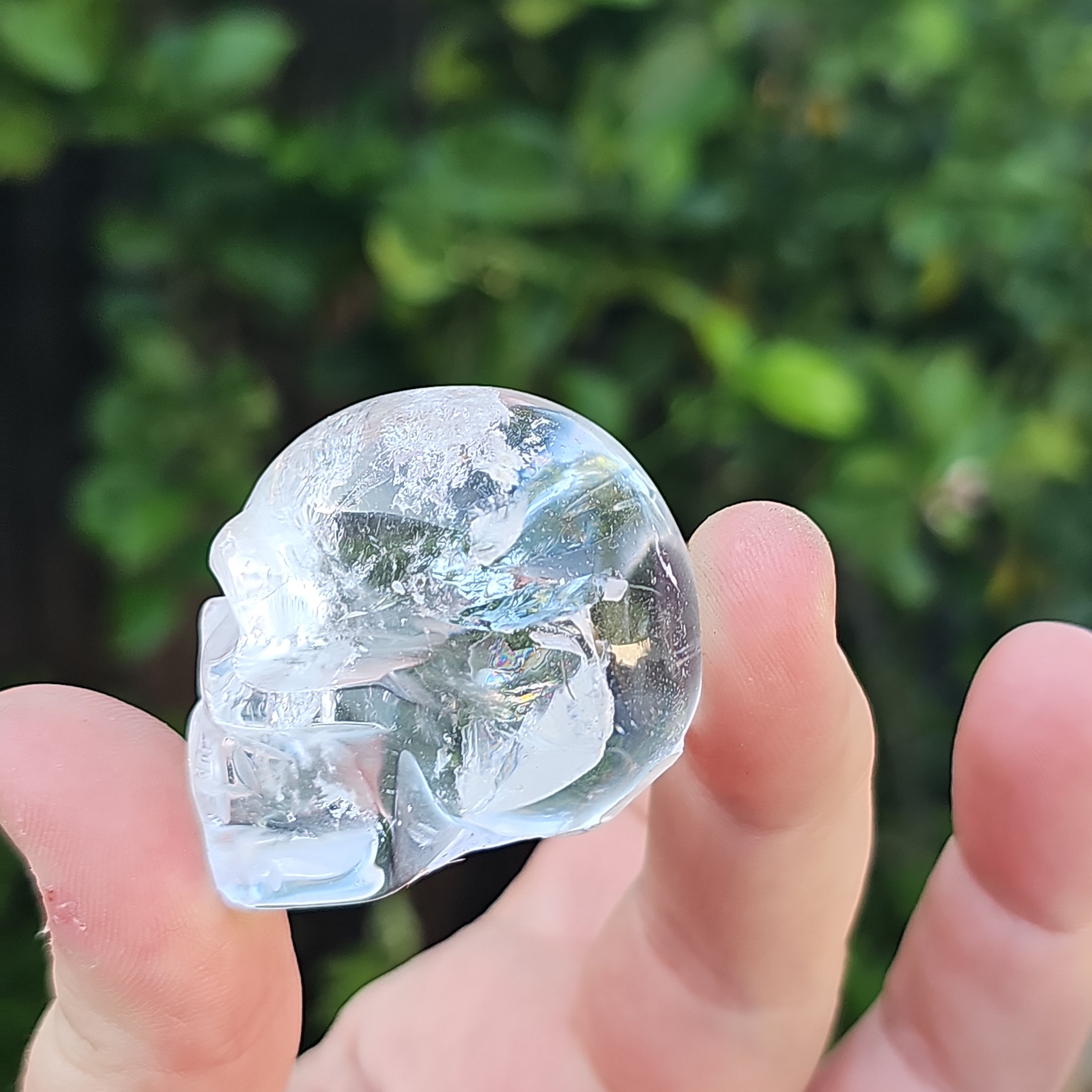 A beautifully handcrafted crystal skull made from high clarity quartz and amethyst, showcasing intricate details and vibrant colors.