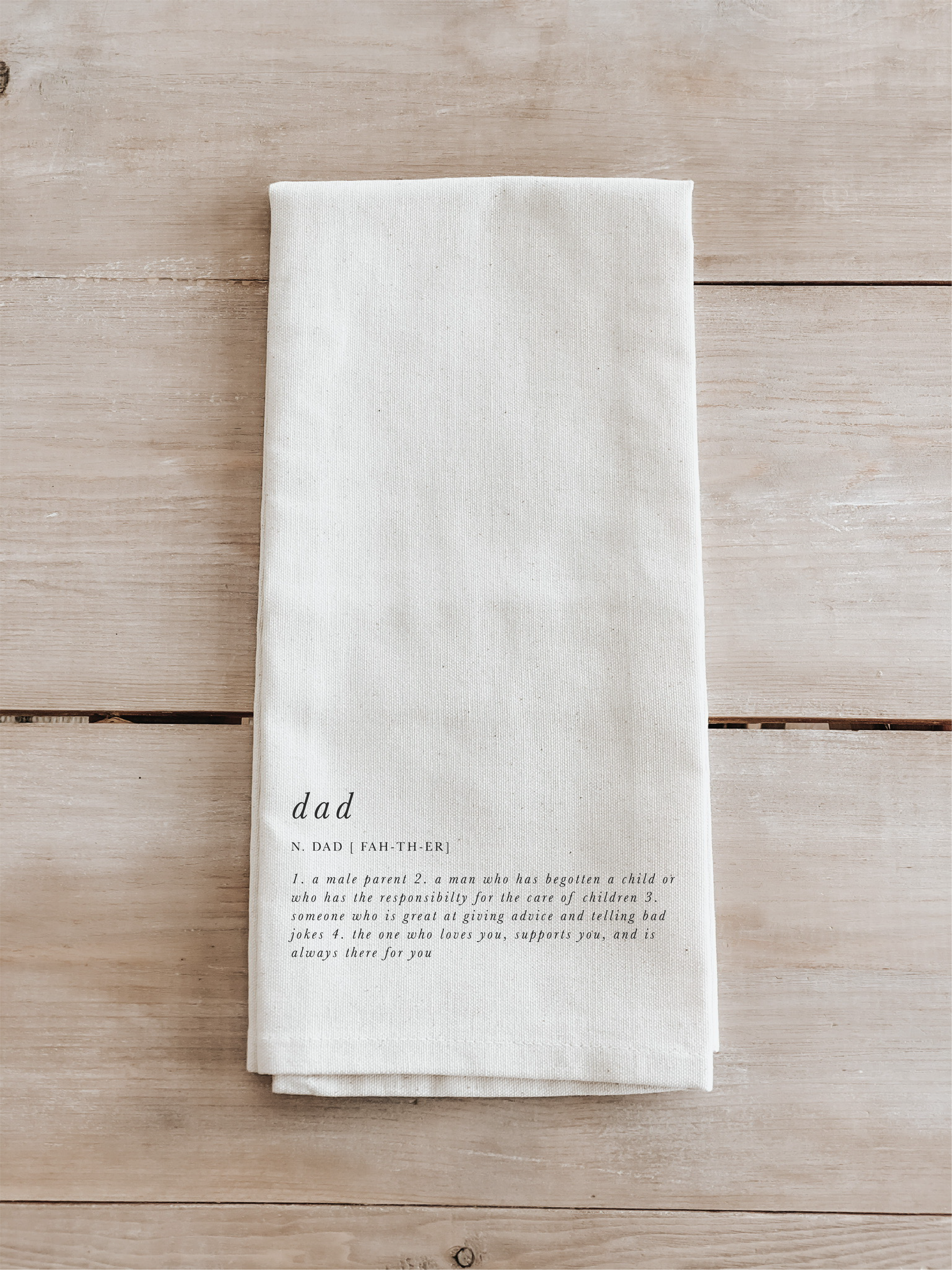 A beautifully designed Dad Definition Tea Towel made from 100% organic cotton, featuring eco-friendly inks in white and natural colors.