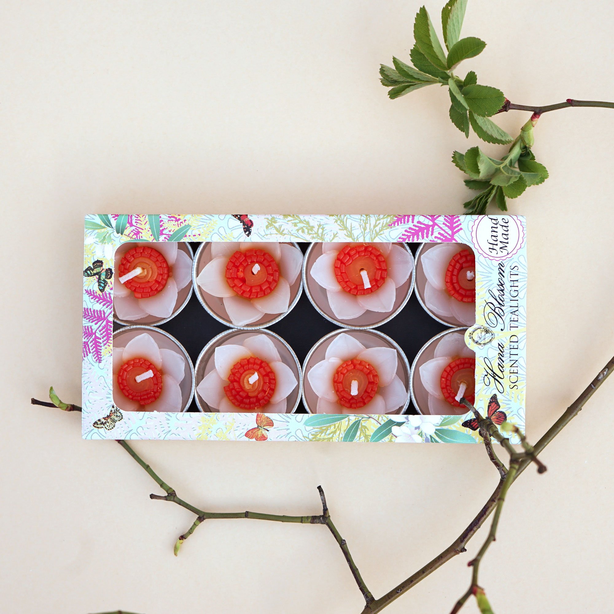 A set of eight handmade daffodil scented tealights in a decorative box, showcasing their floral design and vibrant colors.