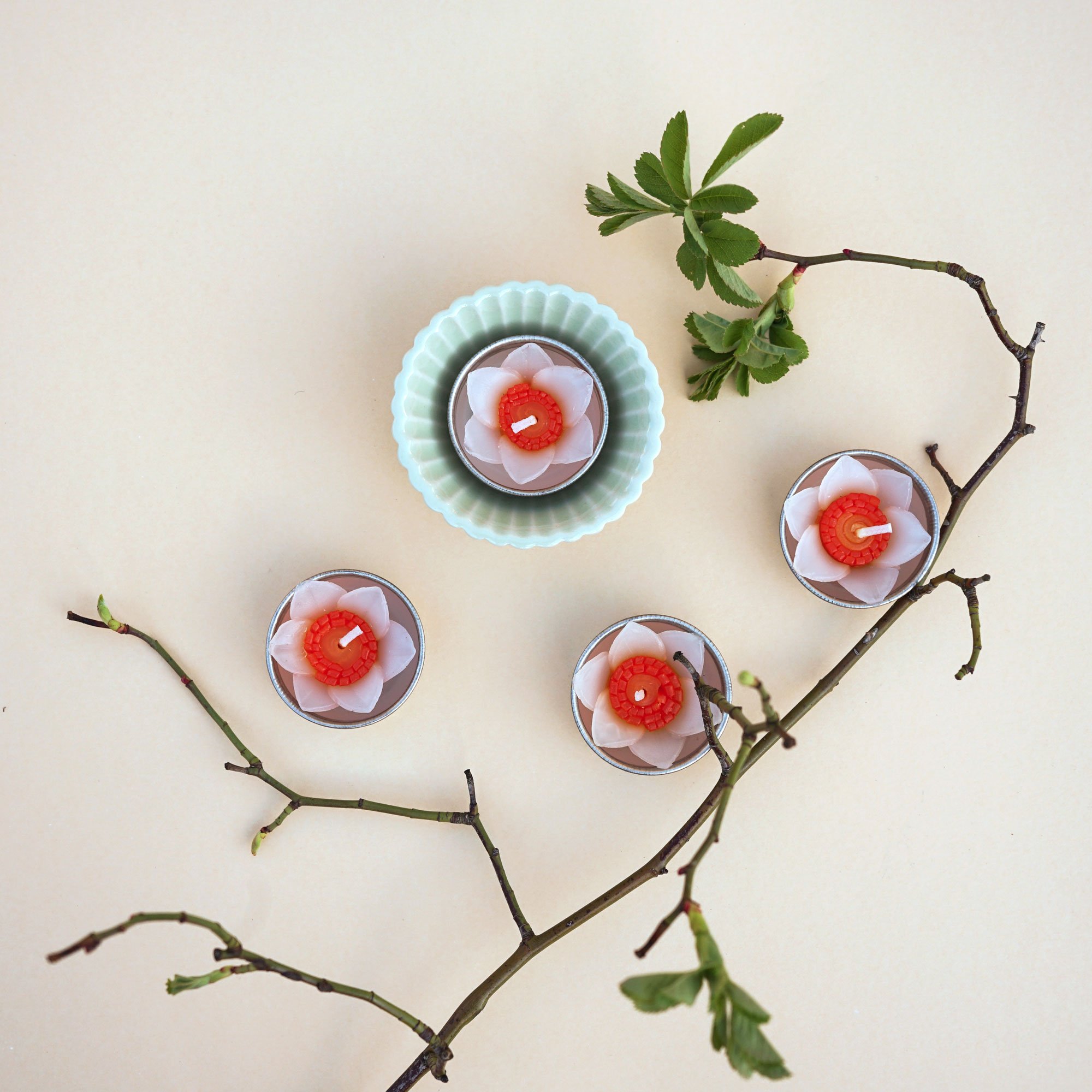 A set of eight handmade daffodil scented tealights in a decorative box, showcasing their floral design and vibrant colors.