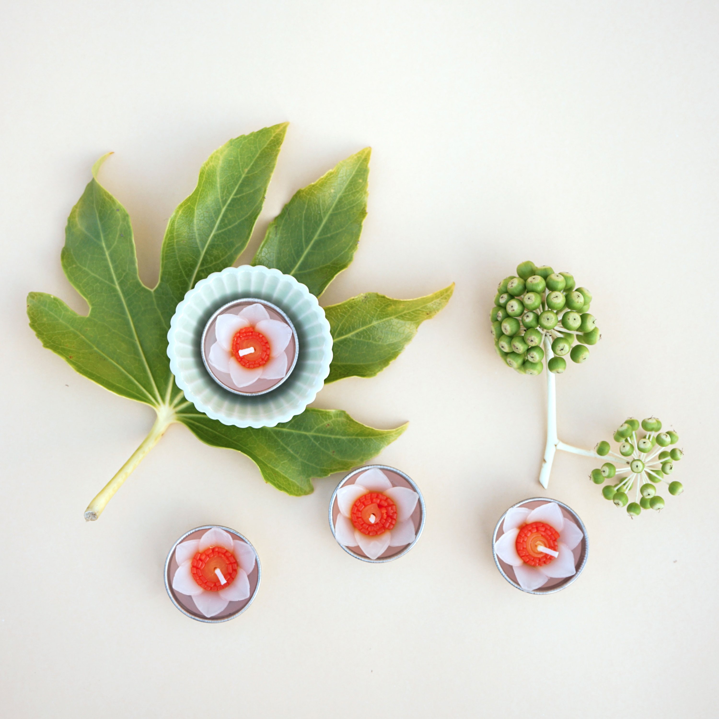 A set of eight handmade daffodil scented tealights in a decorative box, showcasing their floral design and vibrant colors.