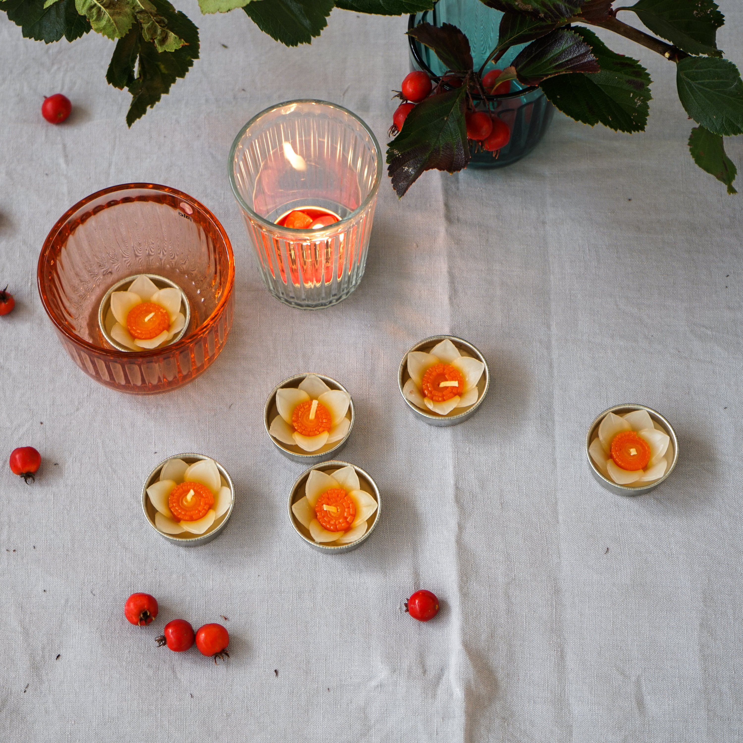 A set of eight handmade daffodil scented tealights in a decorative box, showcasing their floral design and vibrant colors.