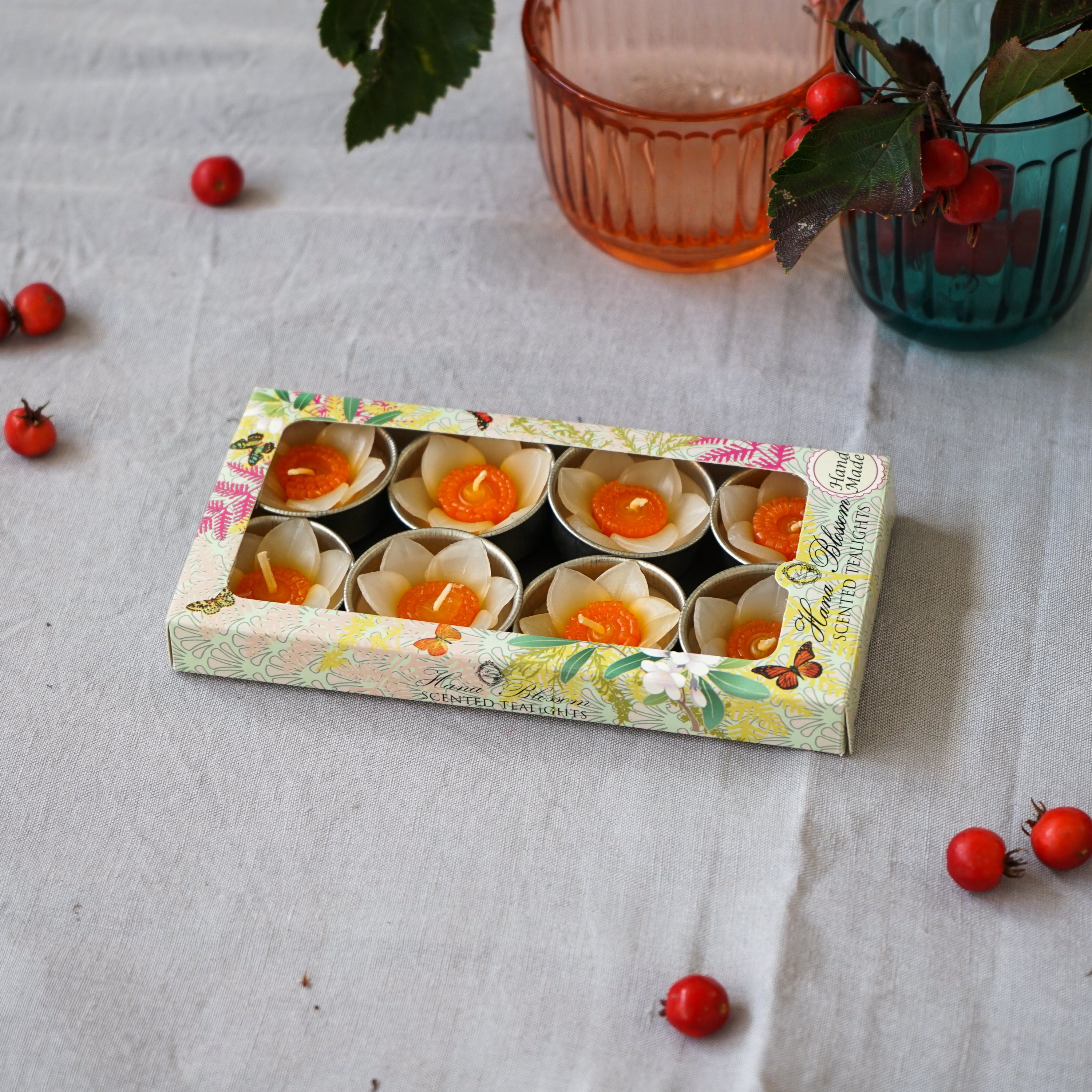 A set of eight handmade daffodil scented tealights in a decorative box, showcasing their floral design and vibrant colors.