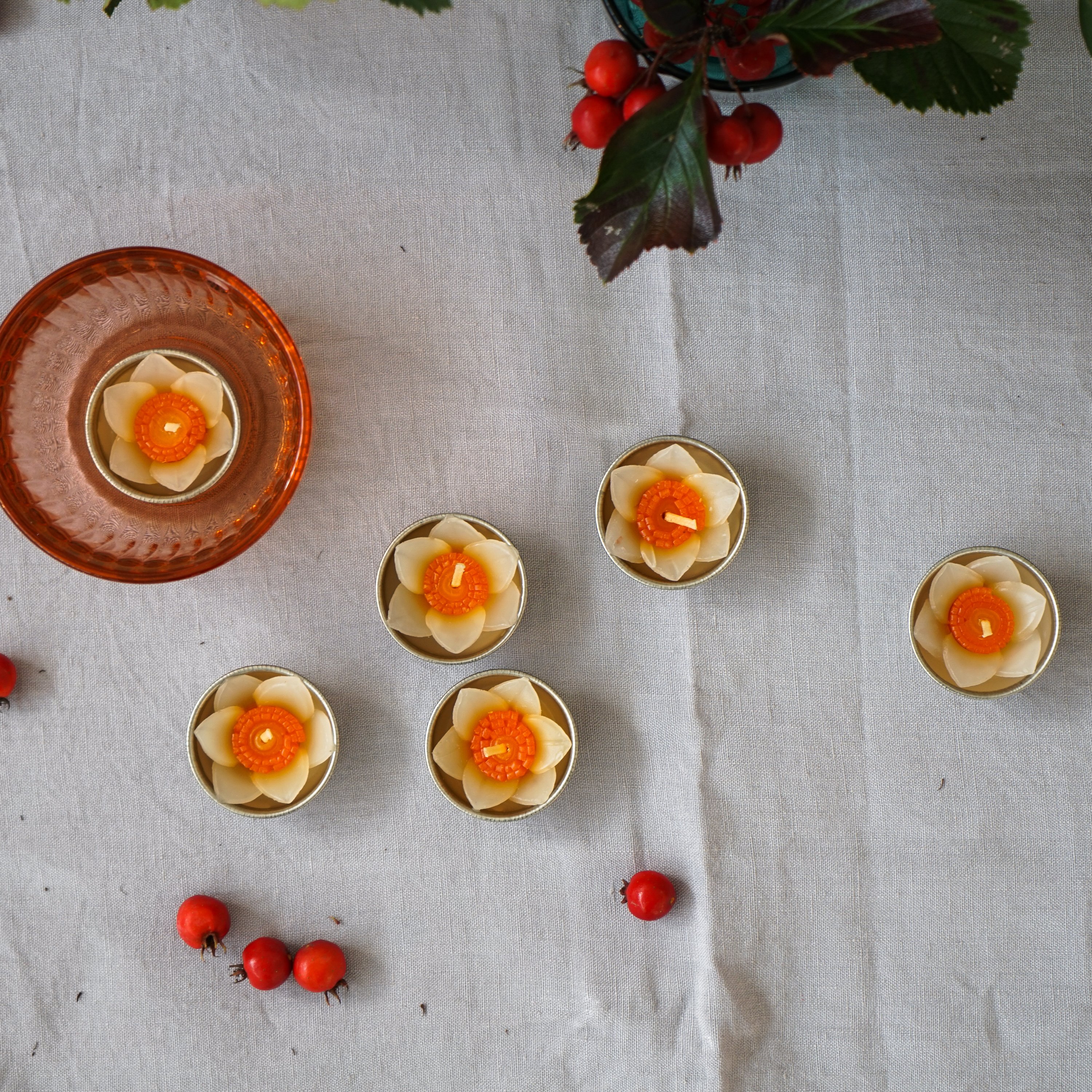 A set of eight handmade daffodil scented tealights in a decorative box, showcasing their floral design and vibrant colors.