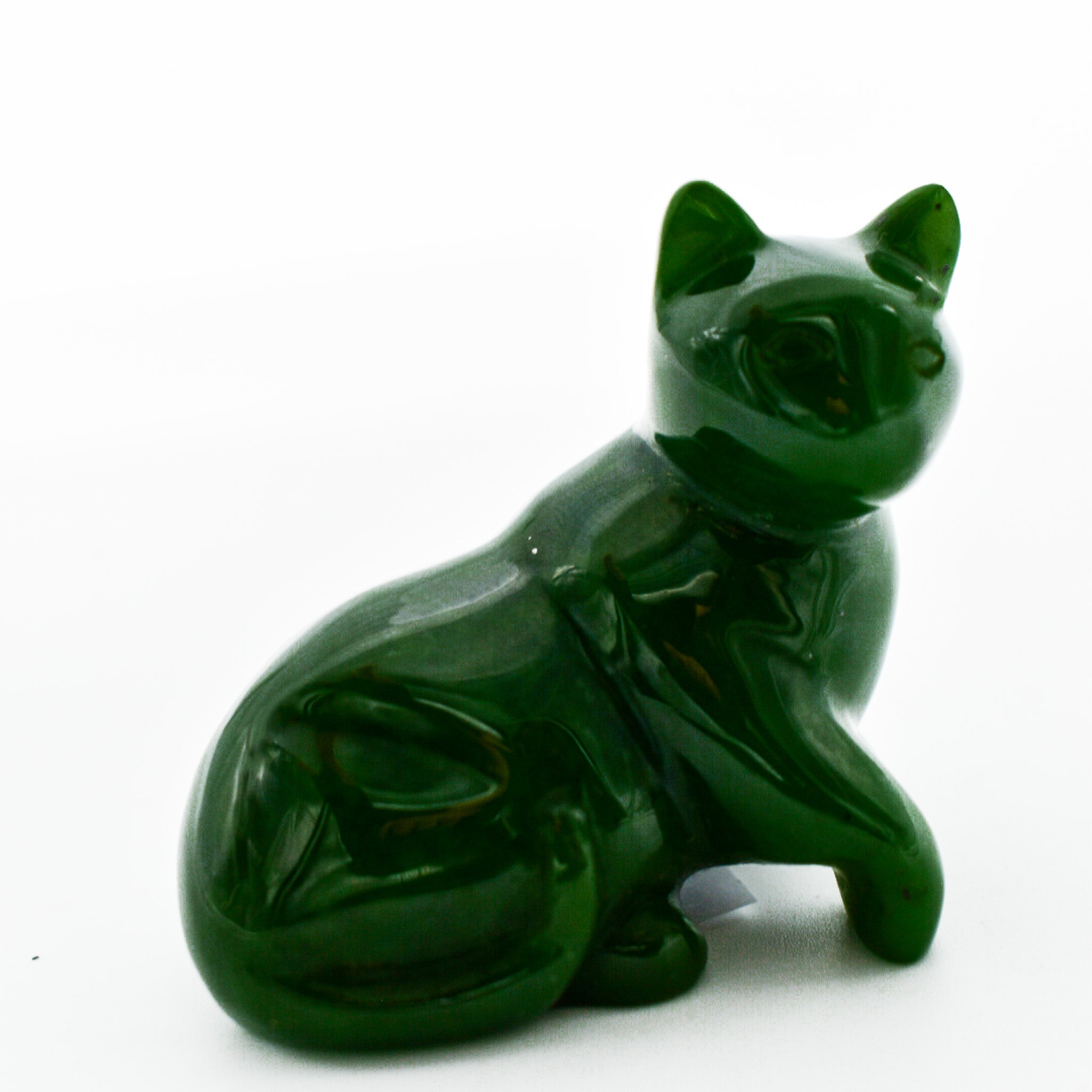 A beautifully hand-carved dark green jade cat figurine showcasing intricate details and unique patterns, symbolizing good luck and protection.