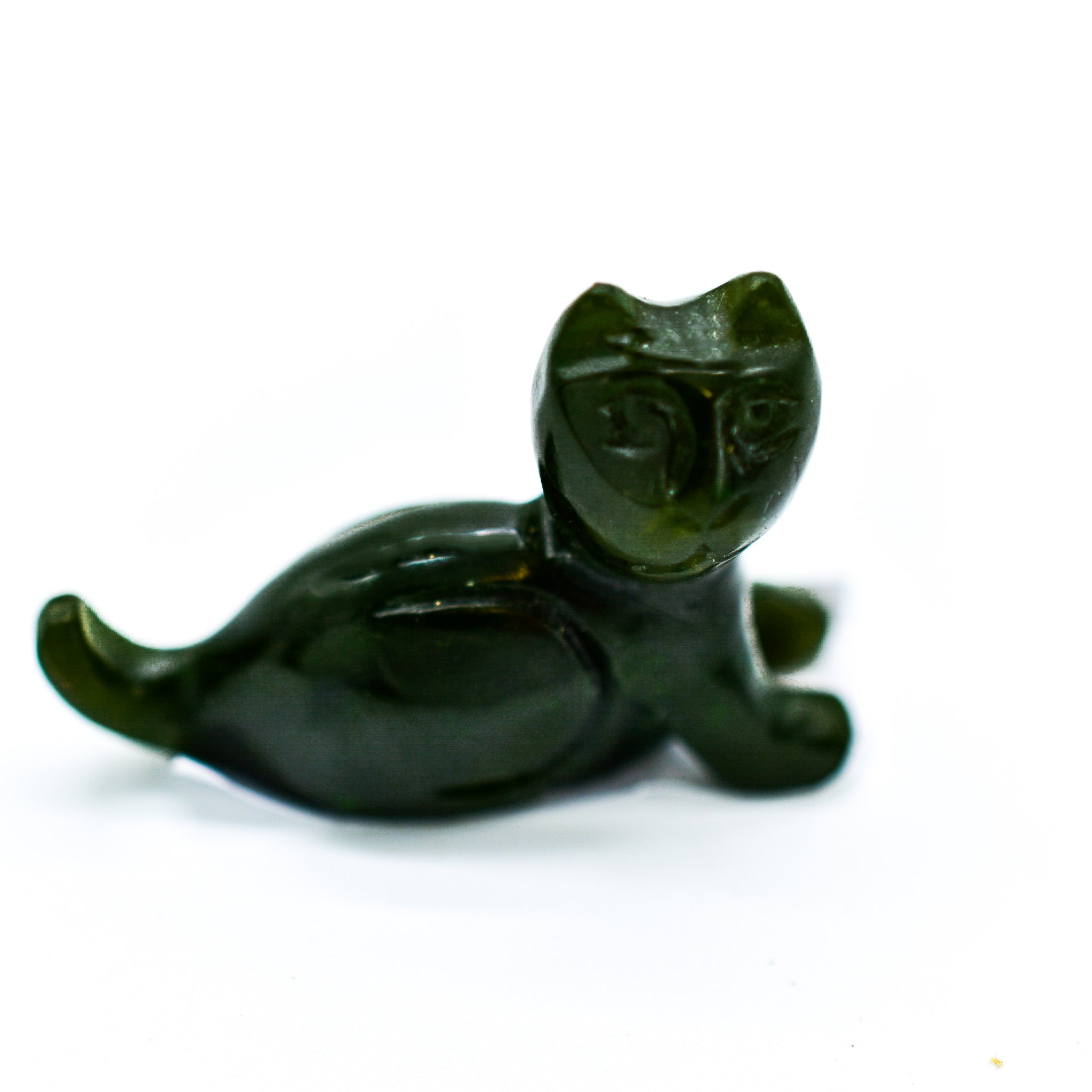 A beautifully hand-carved dark green jade cat figurine showcasing intricate details and unique patterns, symbolizing good luck and protection.