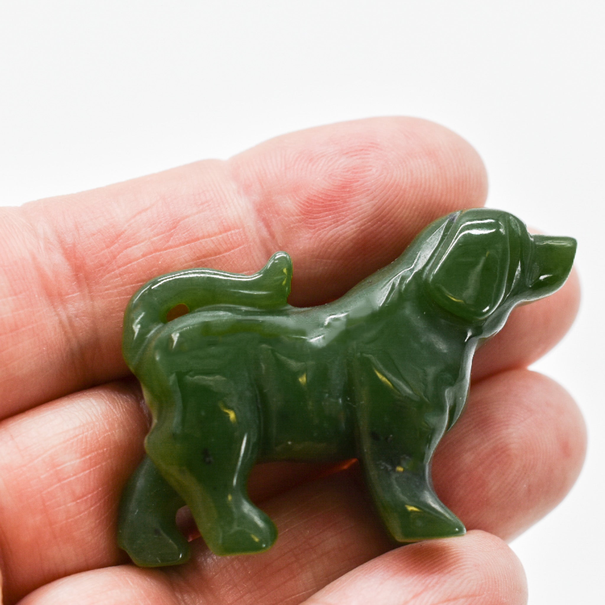 Handcrafted dark green jade dog figurines, showcasing intricate details and rich color, symbolizing luck and protection.