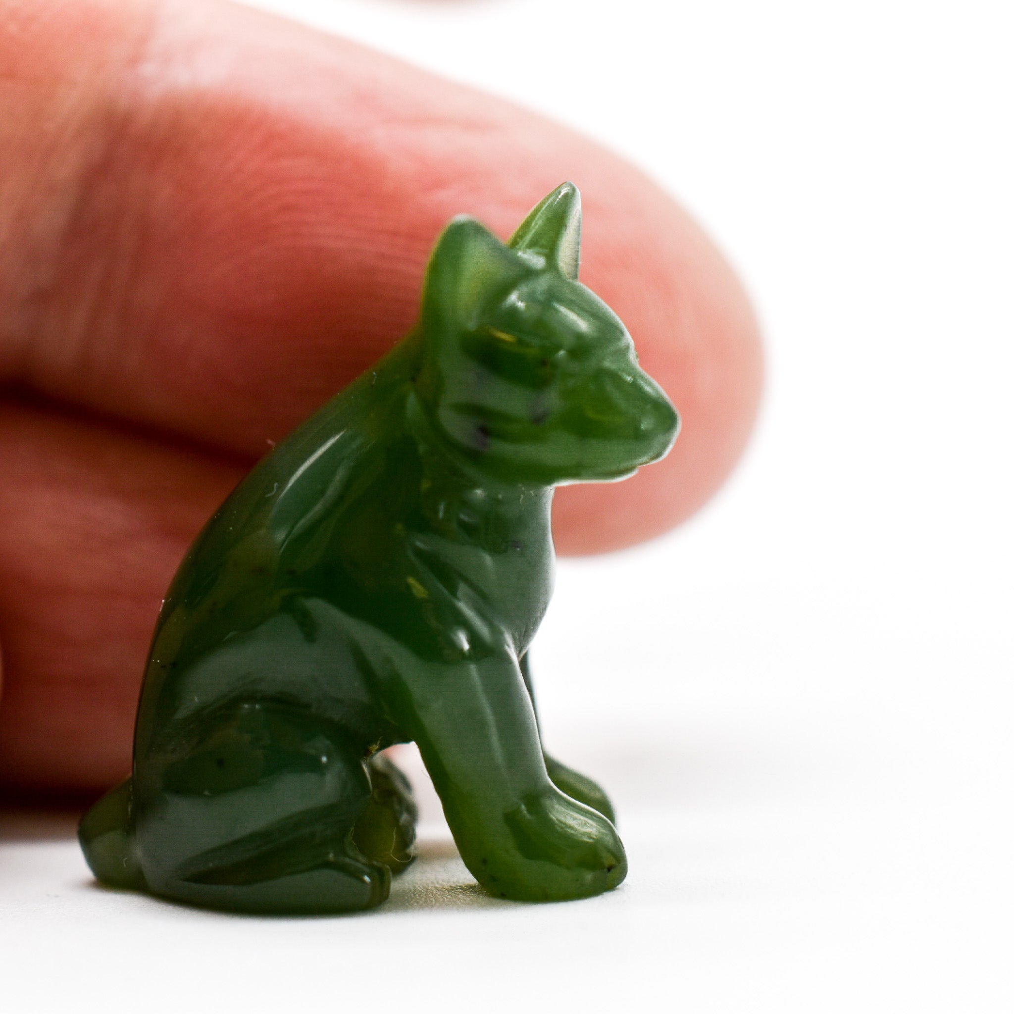 Handcrafted dark green jade dog figurines, showcasing intricate details and rich color, symbolizing luck and protection.