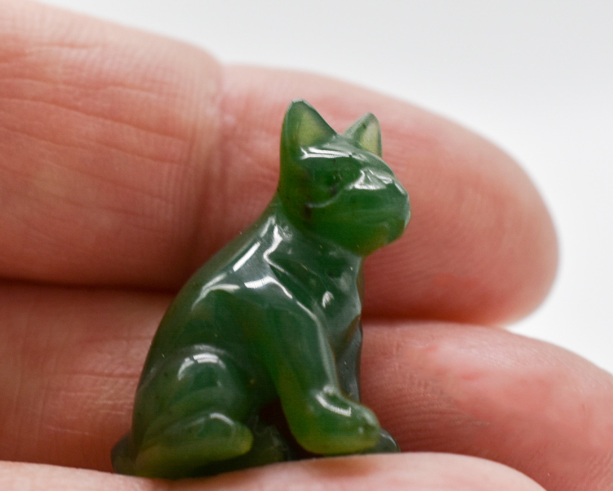 Handcrafted dark green jade dog figurines, showcasing intricate details and rich color, symbolizing luck and protection.