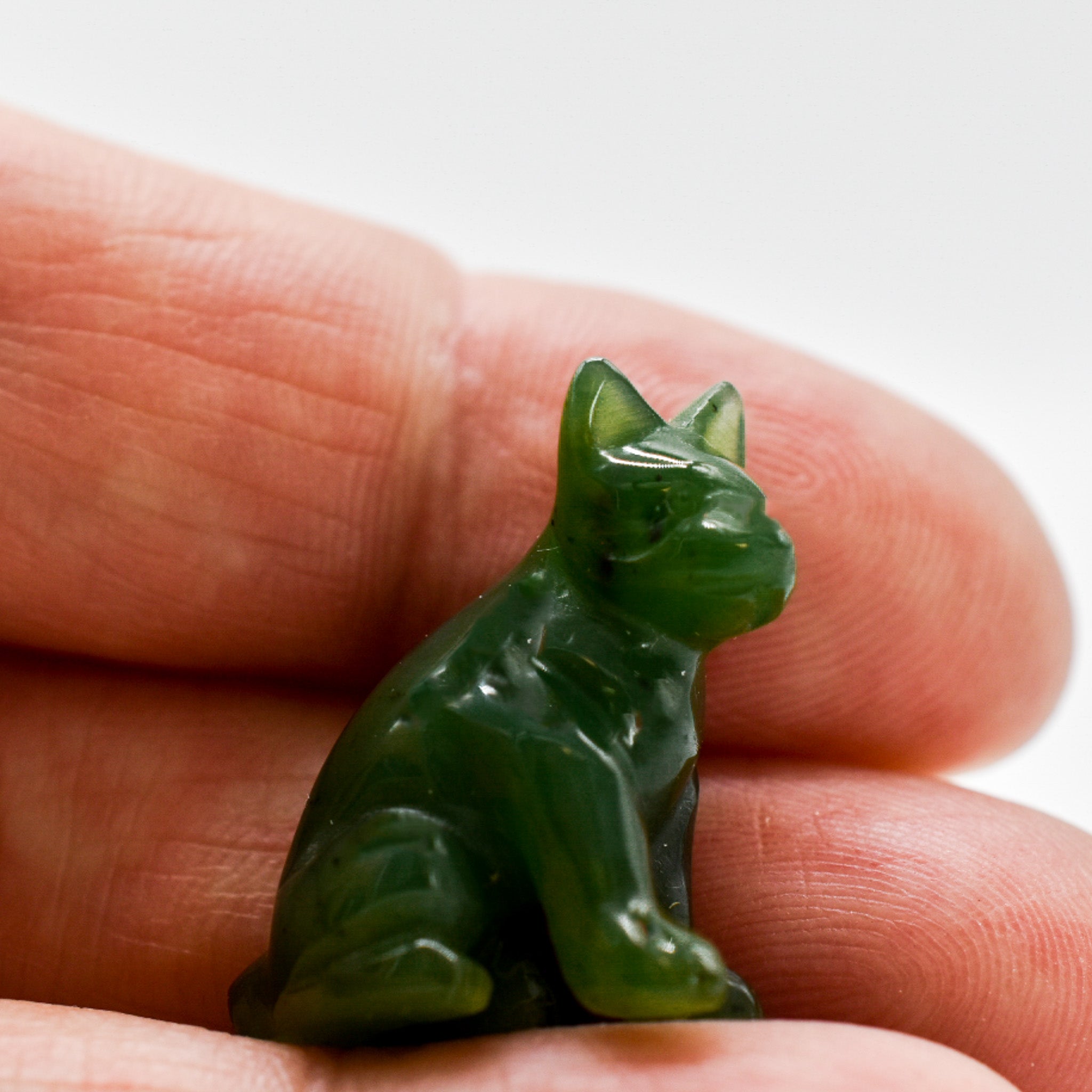 Handcrafted dark green jade dog figurines, showcasing intricate details and rich color, symbolizing luck and protection.