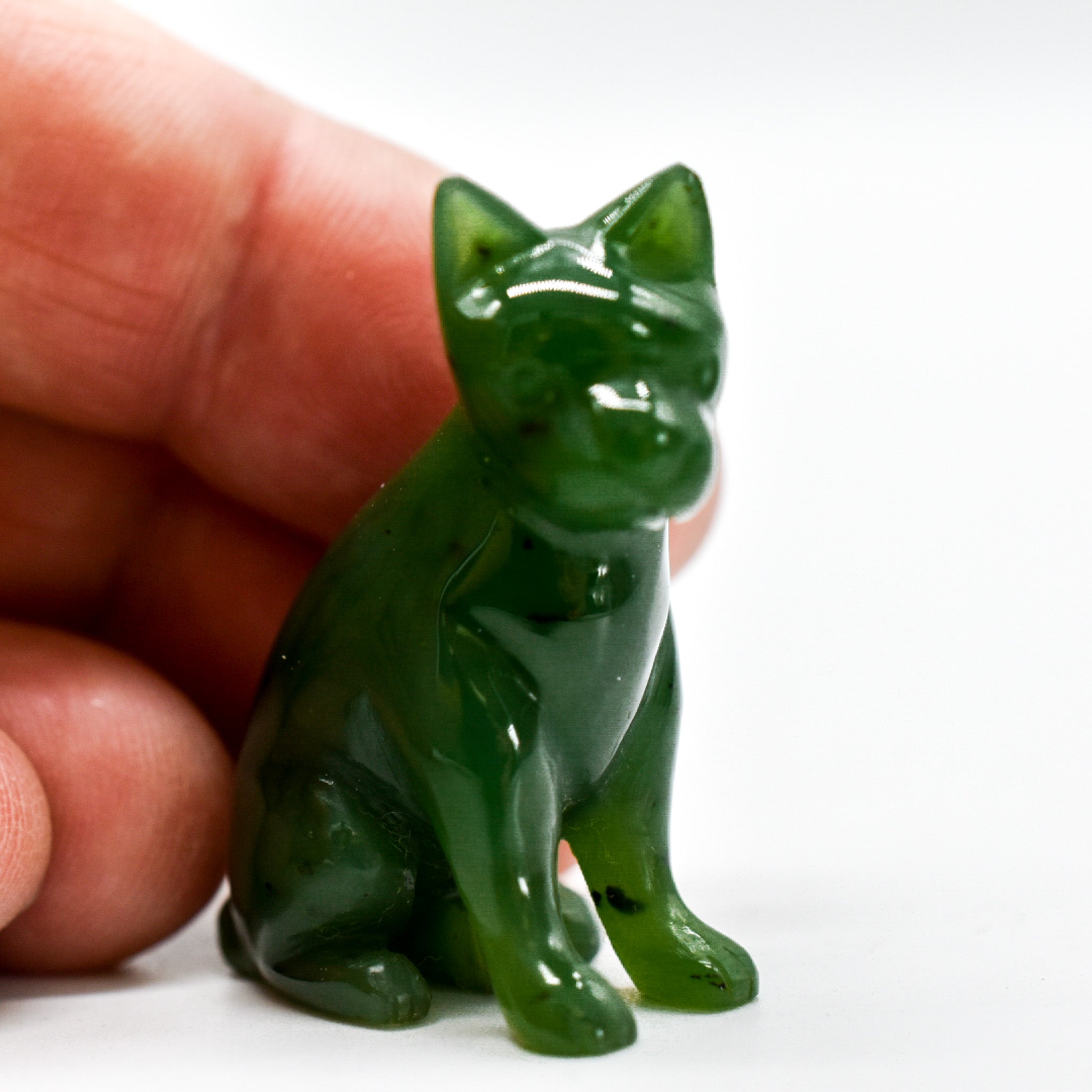 Handcrafted dark green jade dog figurines, showcasing intricate details and rich color, symbolizing luck and protection.