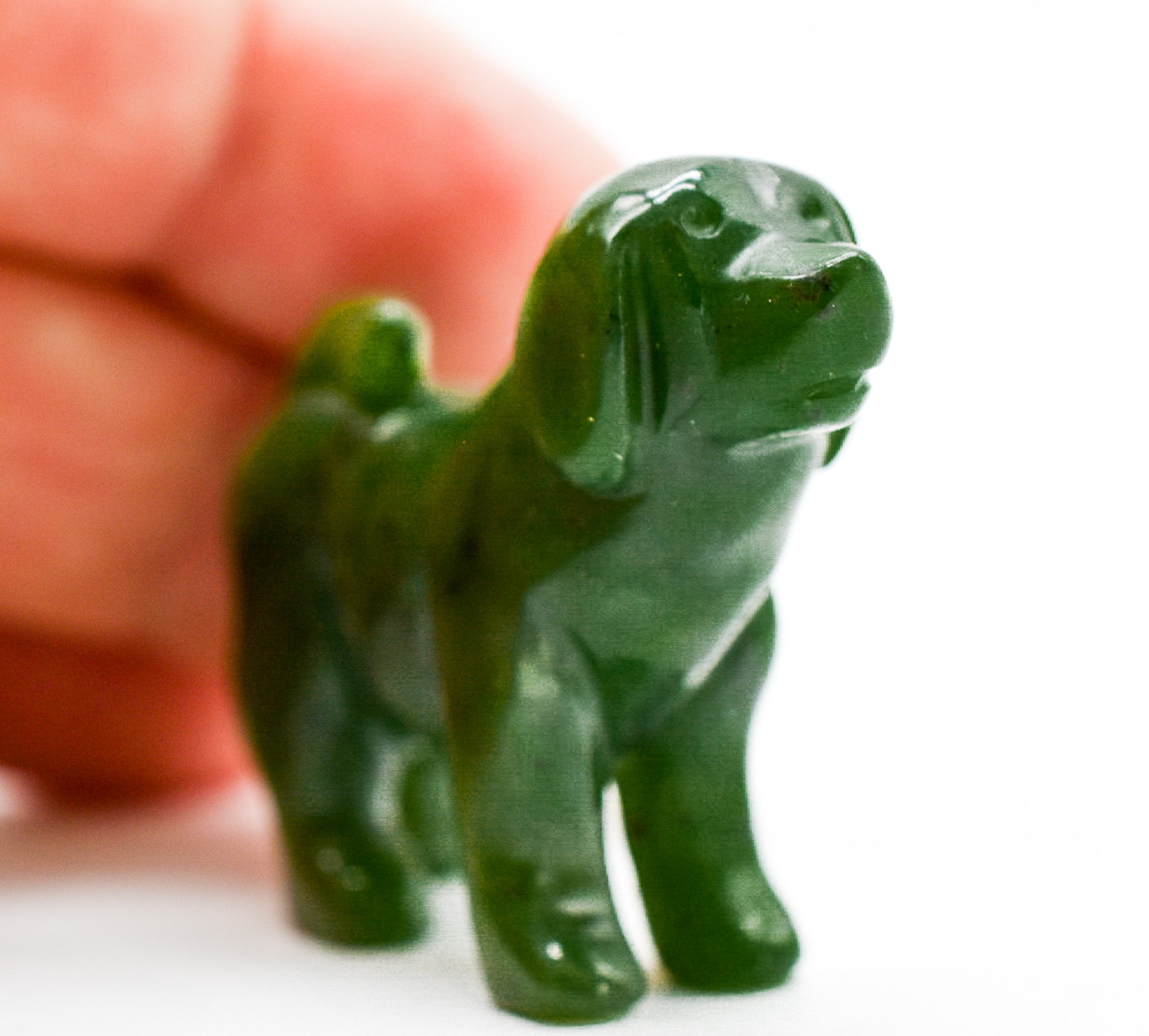 Handcrafted dark green jade dog figurines, showcasing intricate details and rich color, symbolizing luck and protection.