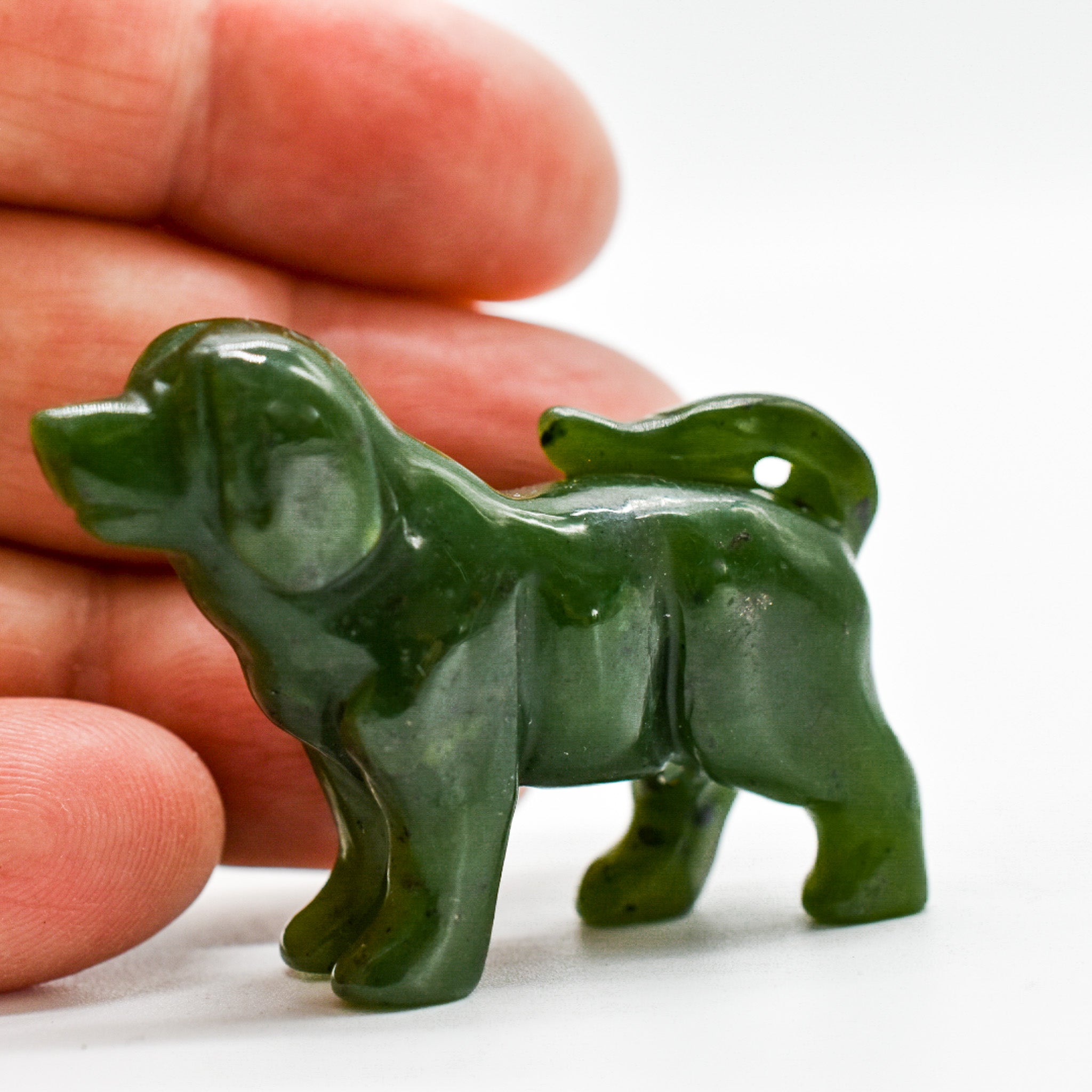 Handcrafted dark green jade dog figurines, showcasing intricate details and rich color, symbolizing luck and protection.