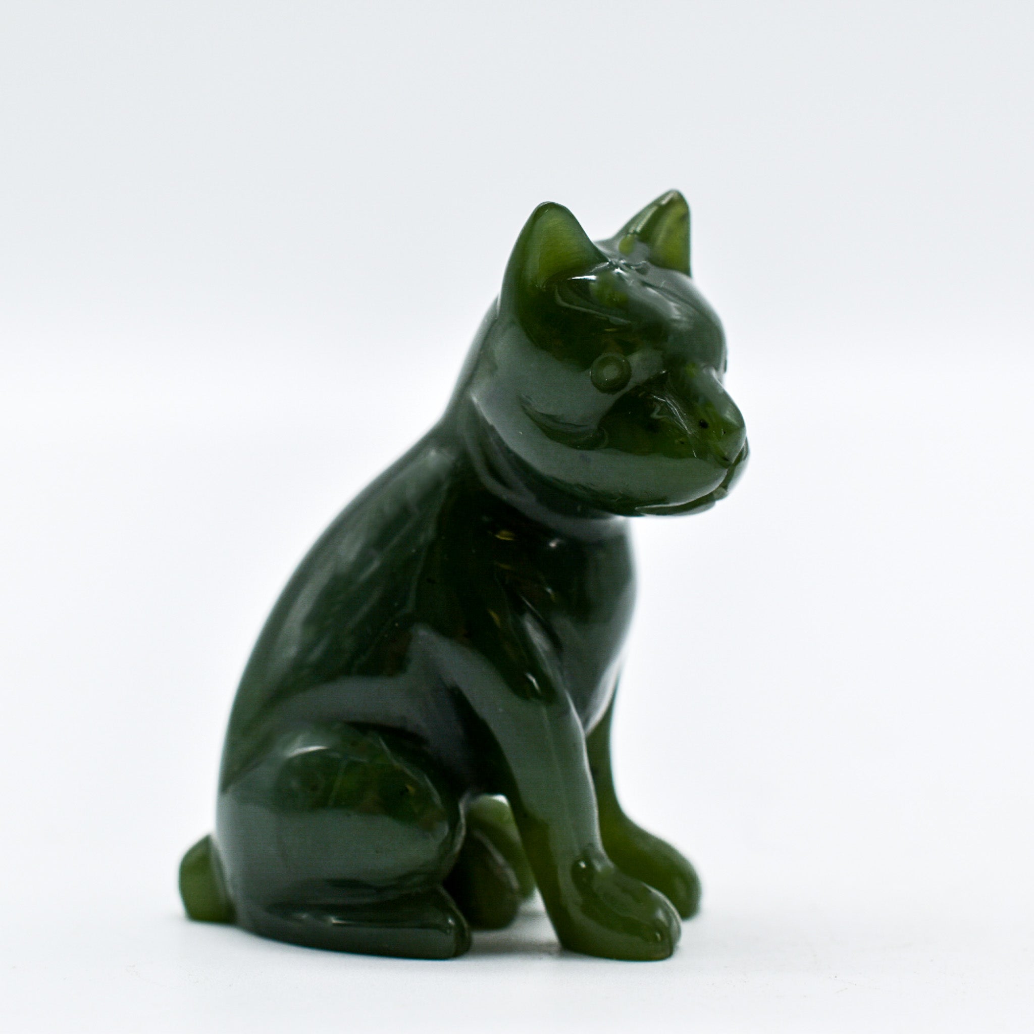 Handcrafted dark green jade dog figurines, showcasing intricate details and rich color, symbolizing luck and protection.