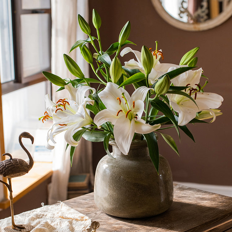 A dark green matte textured glass vase, hand-blown with a unique shape and finish, perfect for home decor.