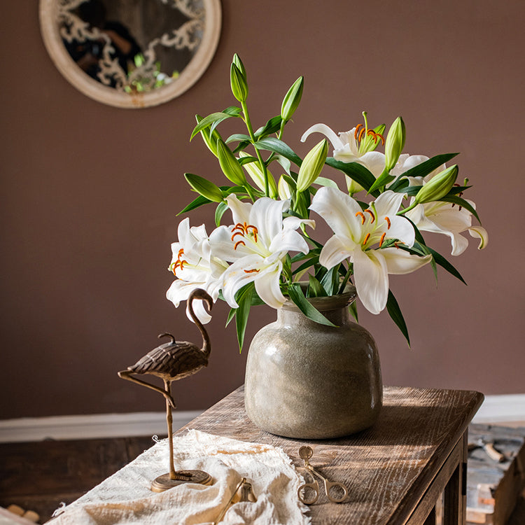 A dark green matte textured glass vase, hand-blown with a unique shape and finish, perfect for home decor.