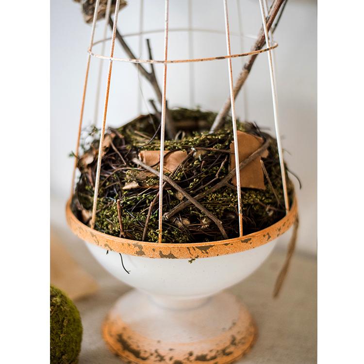 A decorative iron bird cage in white and rust colors, showcasing intricate designs and available in two sizes.