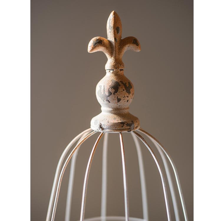 A decorative iron bird cage in white and rust colors, showcasing intricate designs and available in two sizes.