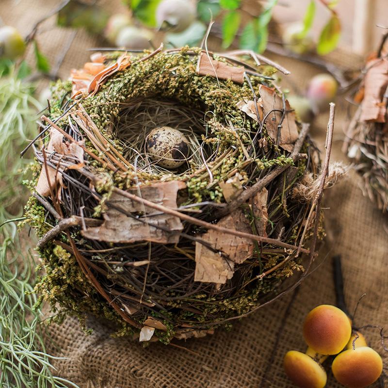 A beautifully crafted Decorative Natural Bird's Nest made from grass and willow, showcasing earthy tones of brown and green.