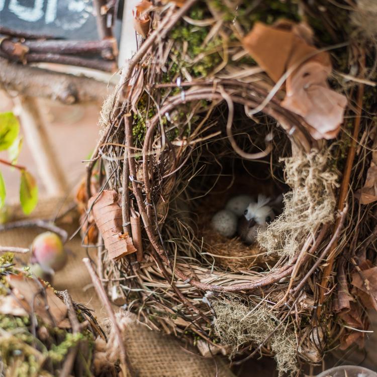 A beautifully crafted Decorative Natural Bird's Nest made from grass and willow, showcasing earthy tones of brown and green.