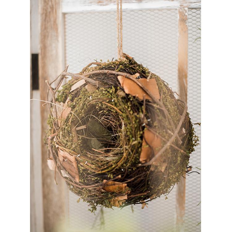 A beautifully crafted Decorative Natural Bird's Nest made from grass and willow, showcasing earthy tones of brown and green.