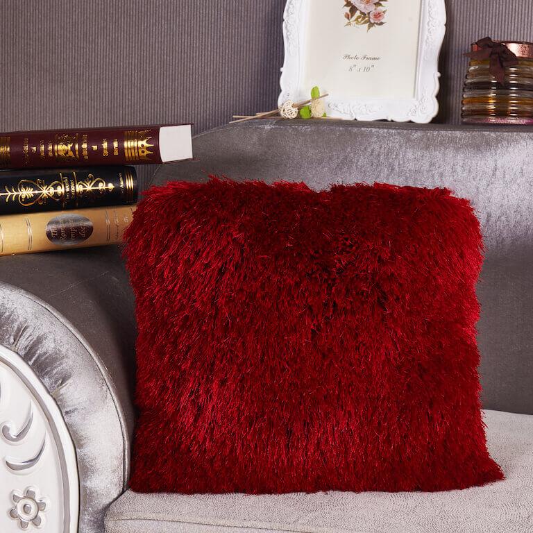 A cozy red decorative shaggy pillow, hand tufted, square shape, measuring 18 inches by 18 inches, perfect for home decor.