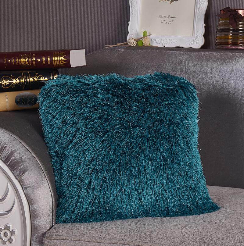 A cozy turquoise decorative shaggy pillow with Lurex detailing, hand tufted and square-shaped, measuring 18x18 inches.