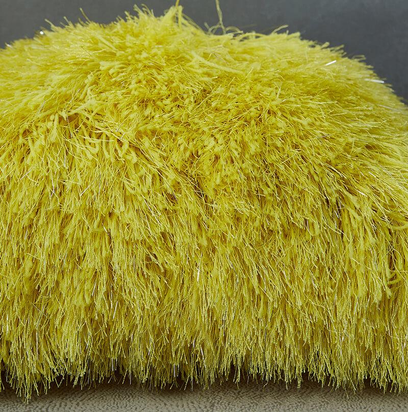 Decorative shaggy pillow in vibrant yellow with lurex threads, showcasing a retro modern design, perfect for adding glamour to any room.