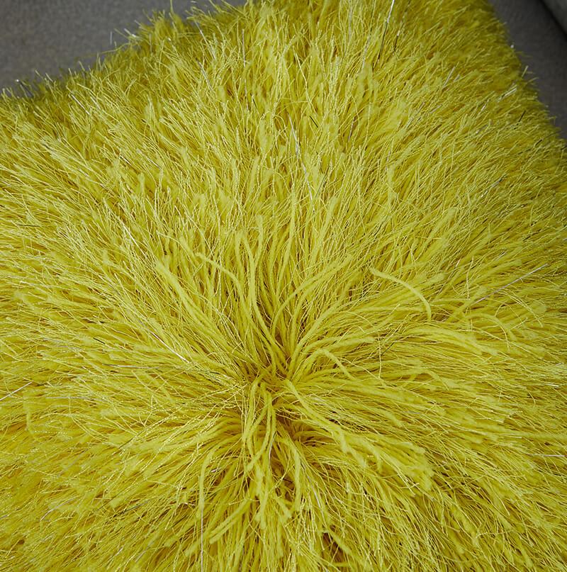 Decorative shaggy pillow in vibrant yellow with lurex threads, showcasing a retro modern design, perfect for adding glamour to any room.