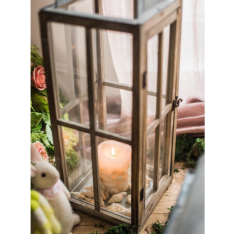 A beautifully crafted decorative table lantern made of wood and glass, featuring a rustic design with a candle inside, perfect for home decor.