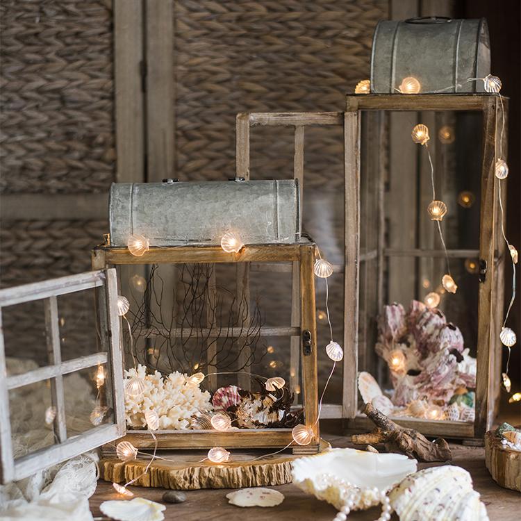 A beautifully crafted decorative table lantern made of wood and glass, featuring a rustic design with a candle inside, perfect for home decor.