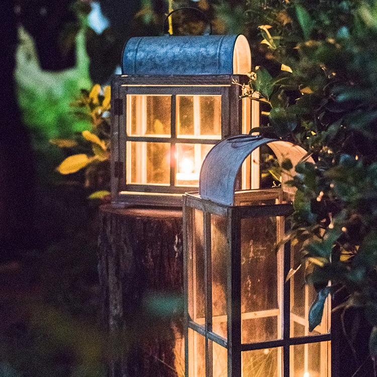 A beautifully crafted decorative table lantern made of wood and glass, featuring a rustic design with a candle inside, perfect for home decor.