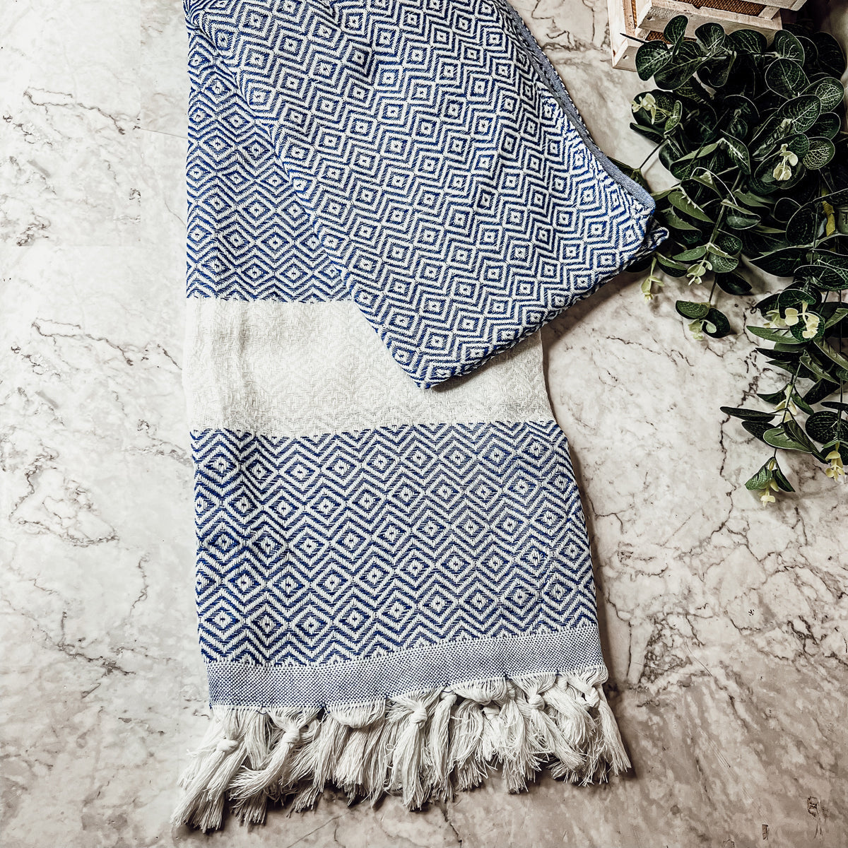 A luxurious Diamond Towel 200GSM in blue with decorative tassels, showcasing its oversized design and unique diamond pattern.