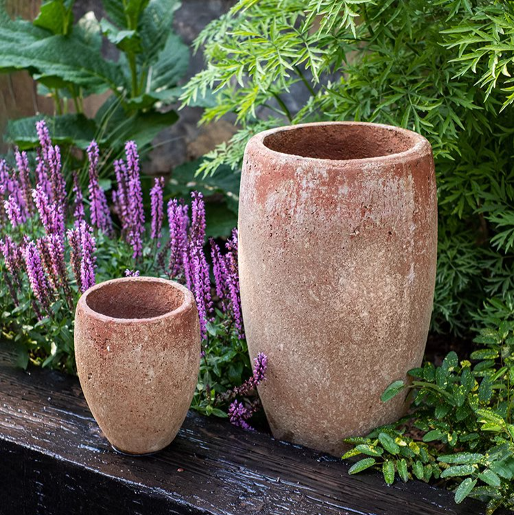 Tall distressed cement plant pot in terracotta color, showcasing a rustic design suitable for indoor and outdoor use.