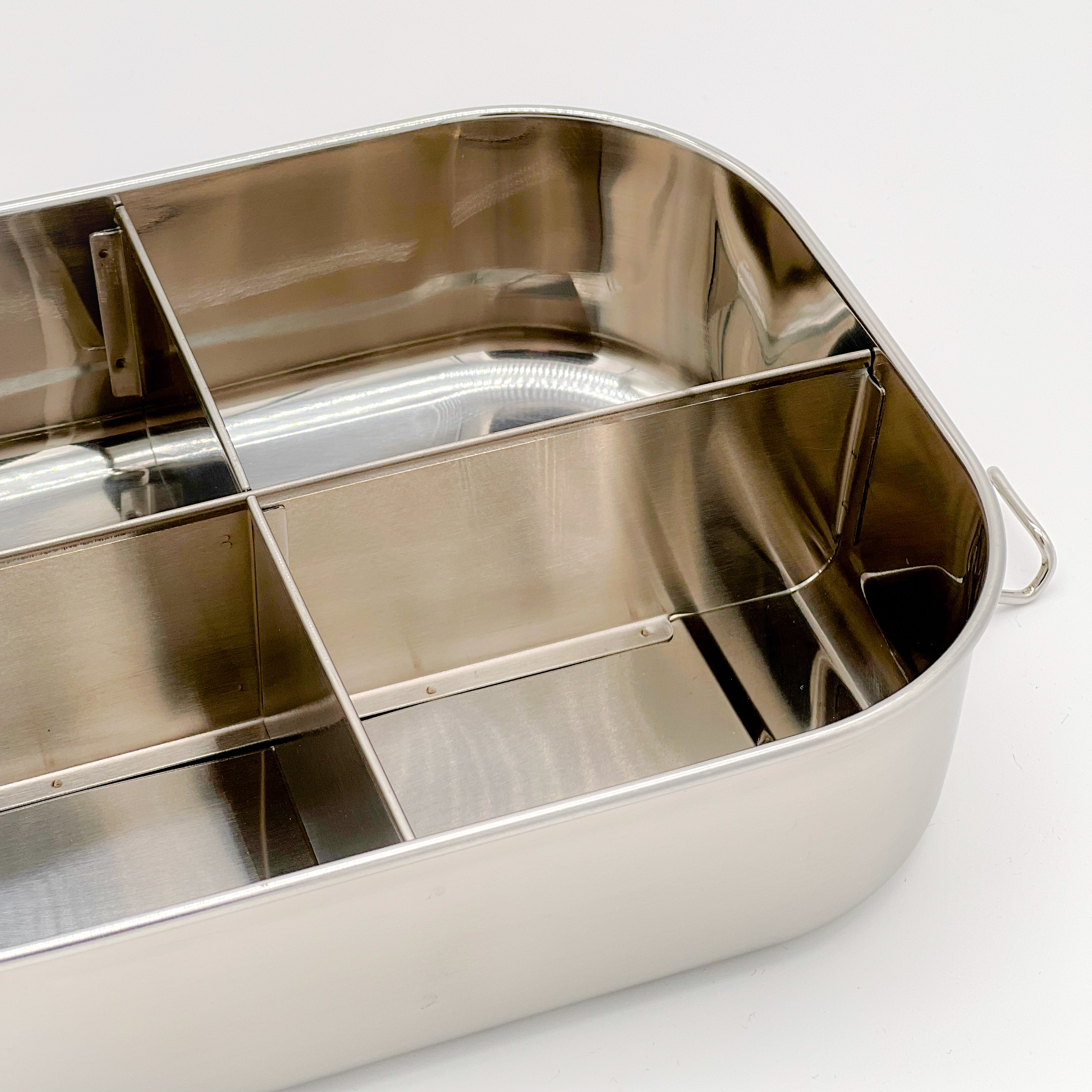 Stainless steel divided food container with three compartments, ideal for meal prep and on-the-go lunches, showcasing its sleek design and durable build.