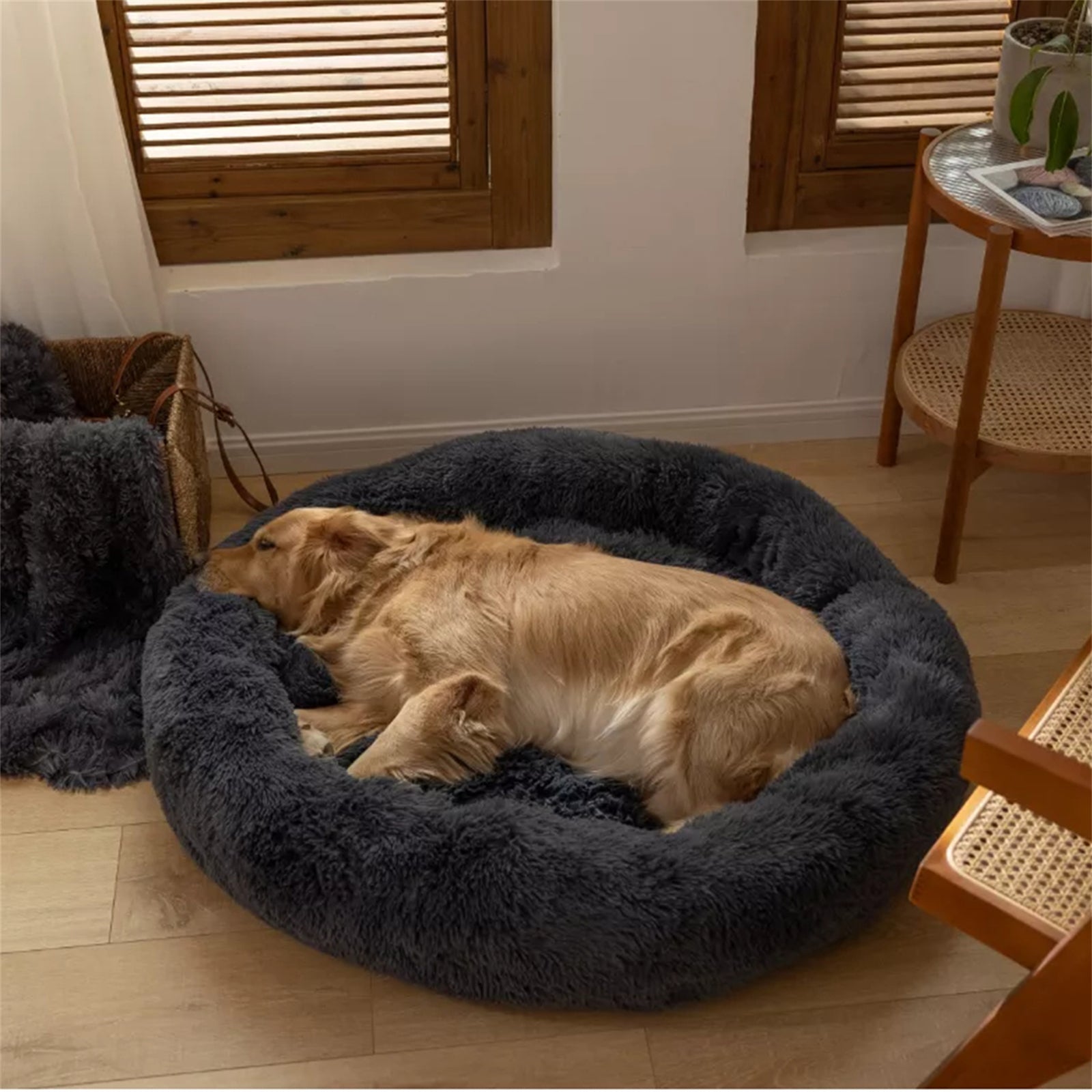 A dark gray plush round dog bed designed for comfort, featuring faux shag fur and a cozy nest shape for pets to snuggle into.