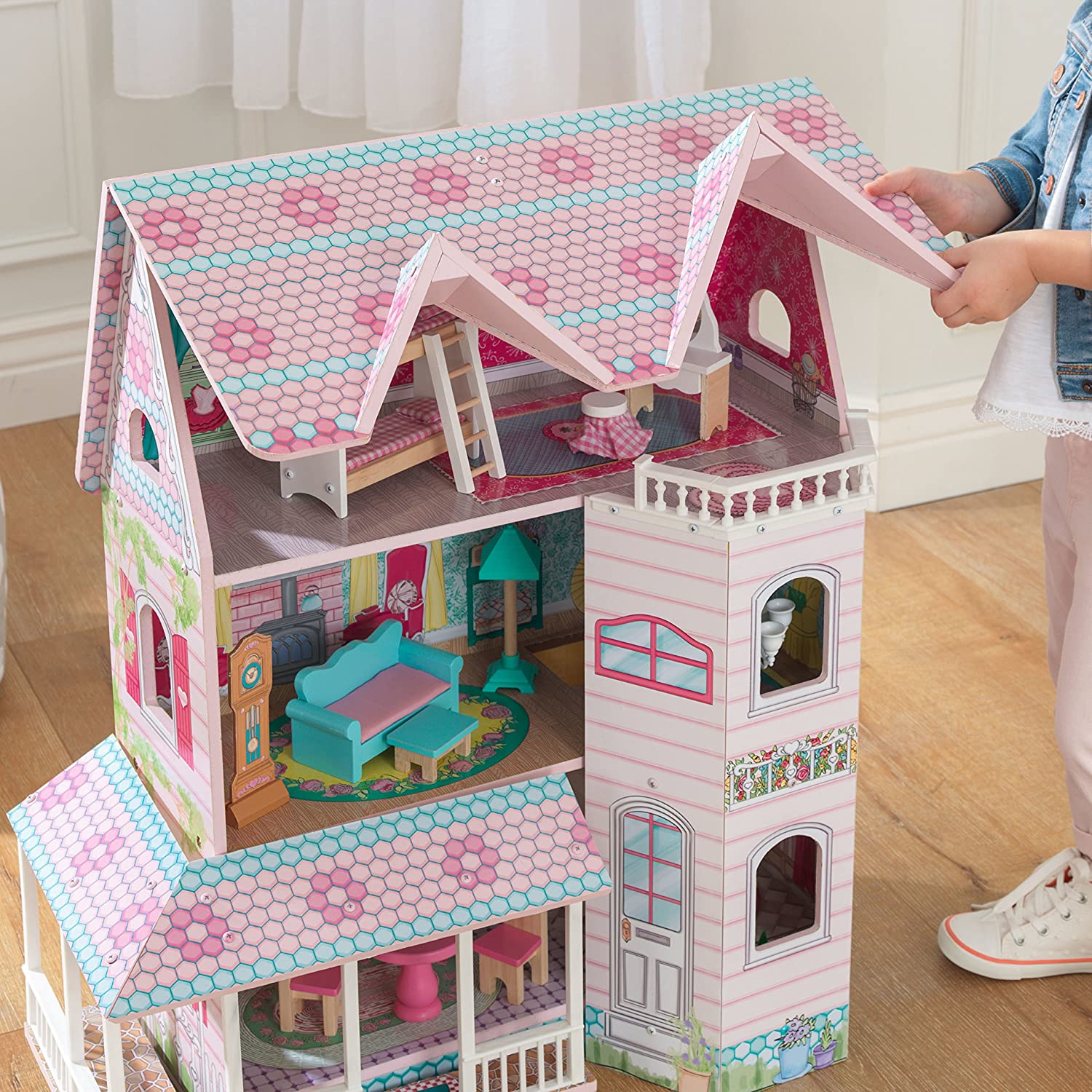 Colorful dollhouse with furniture, featuring three levels and five rooms, designed for imaginative play.