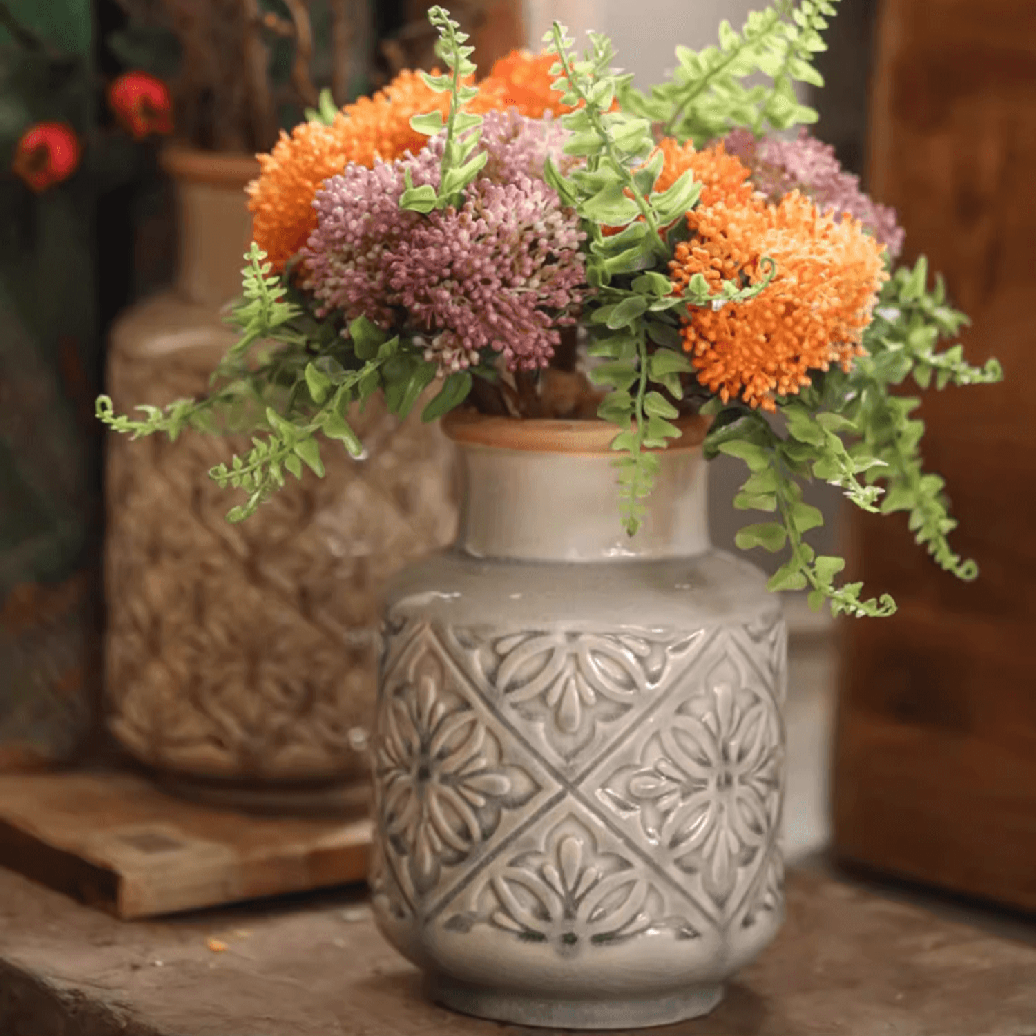 Handmade ceramic vase with a unique embossed pattern in tan, gray, and brown colors, showcasing its elegant glazed finish.