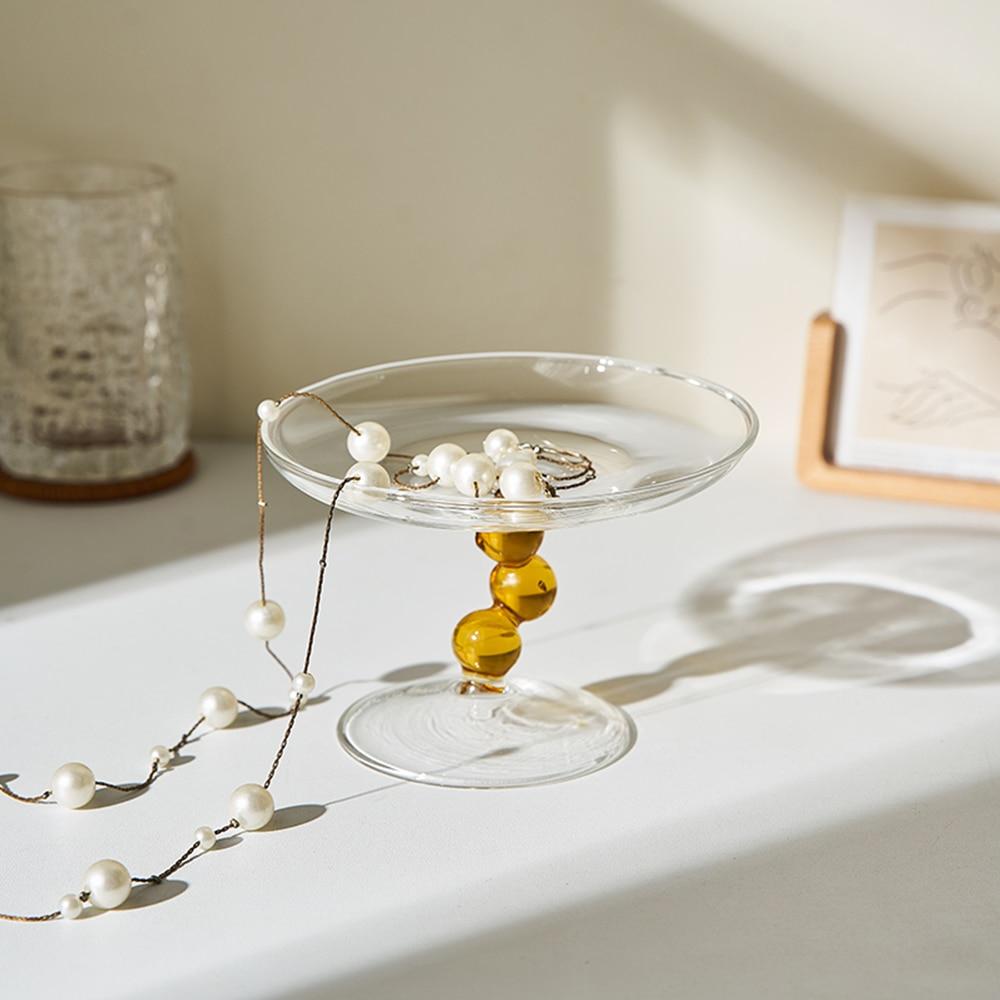 A vintage-inspired Dot Glass Catchall dish, elegantly designed to hold trinkets and jewelry, featuring a unique glass finish.