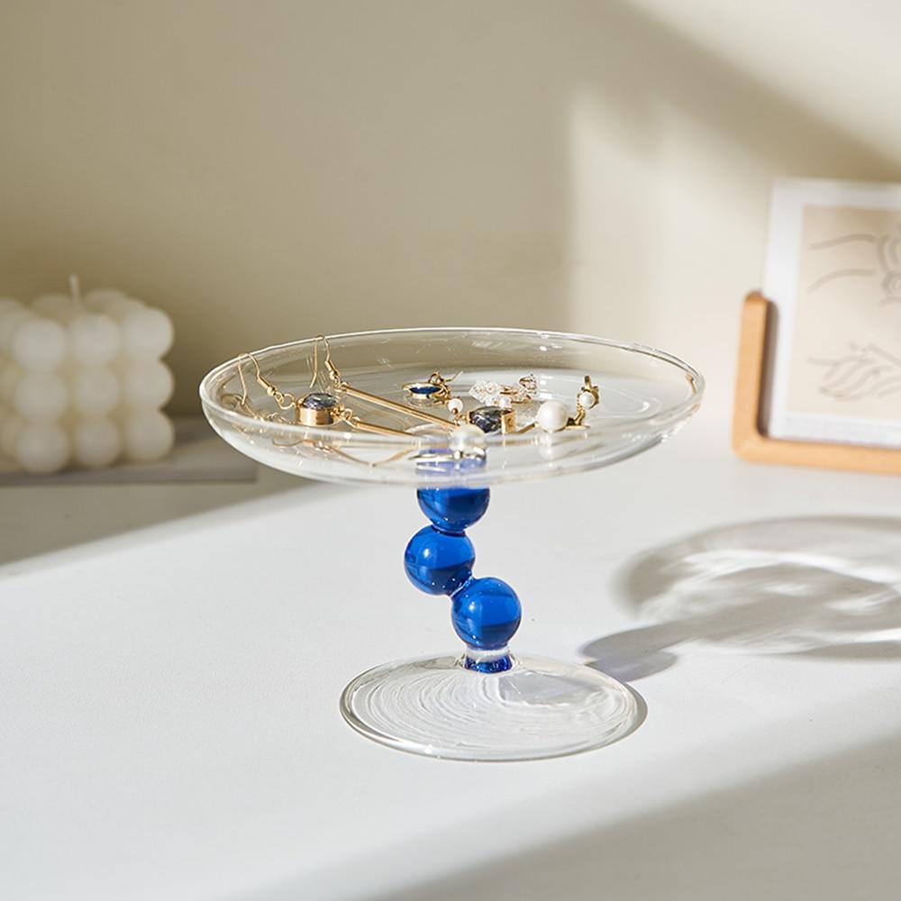 A vintage-inspired Dot Glass Catchall dish, elegantly designed to hold trinkets and jewelry, featuring a unique glass finish.