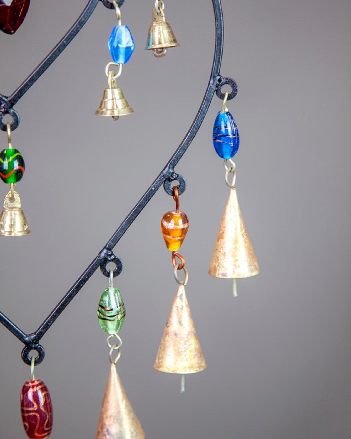 A colorful double heart design hanging chime made of glass beads and brass bells, showcasing vibrant colors and intricate craftsmanship.