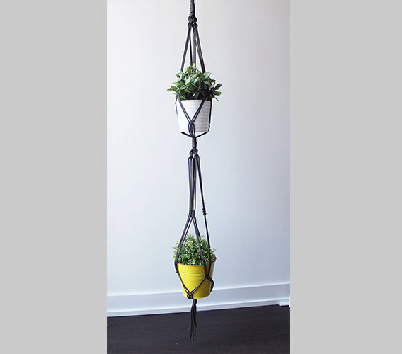 A beautifully crafted Double Macrame Plant Hanger made from durable paracord nylon, showcasing a vibrant green plant in a stylish indoor setting.