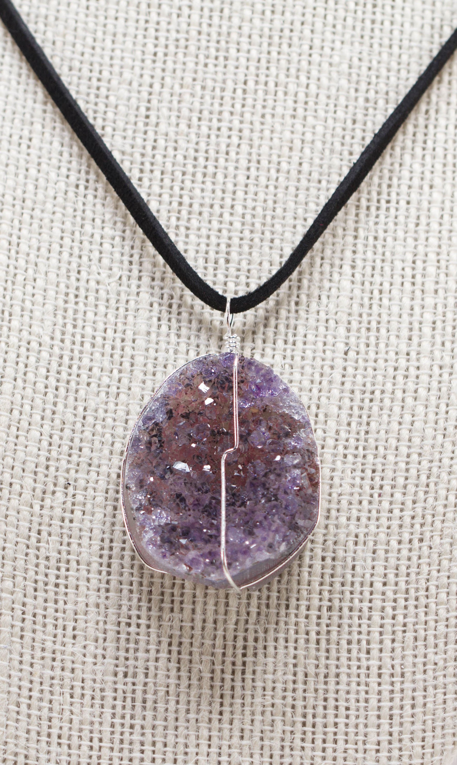 Druse crystal pendant on a leather necklace, showcasing vibrant amethyst, rose amethyst, and citrine crystals secured with silver wire.