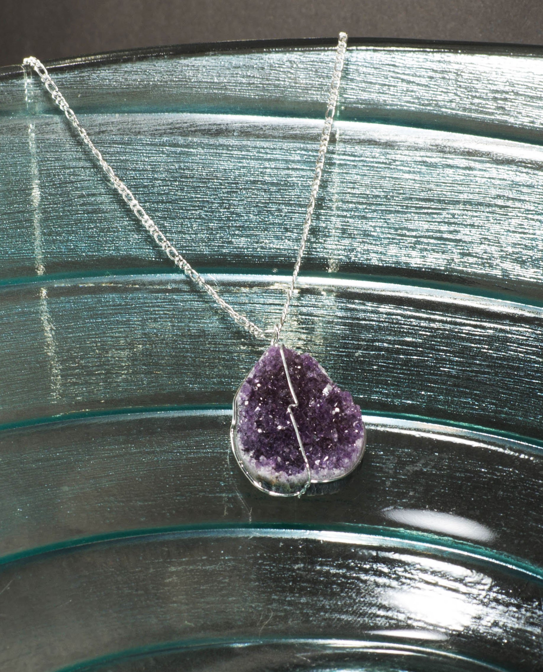 A beautiful druse crystal pendant featuring amethyst, rose amethyst, and citrine crystals, elegantly suspended on a delicate silver chain.