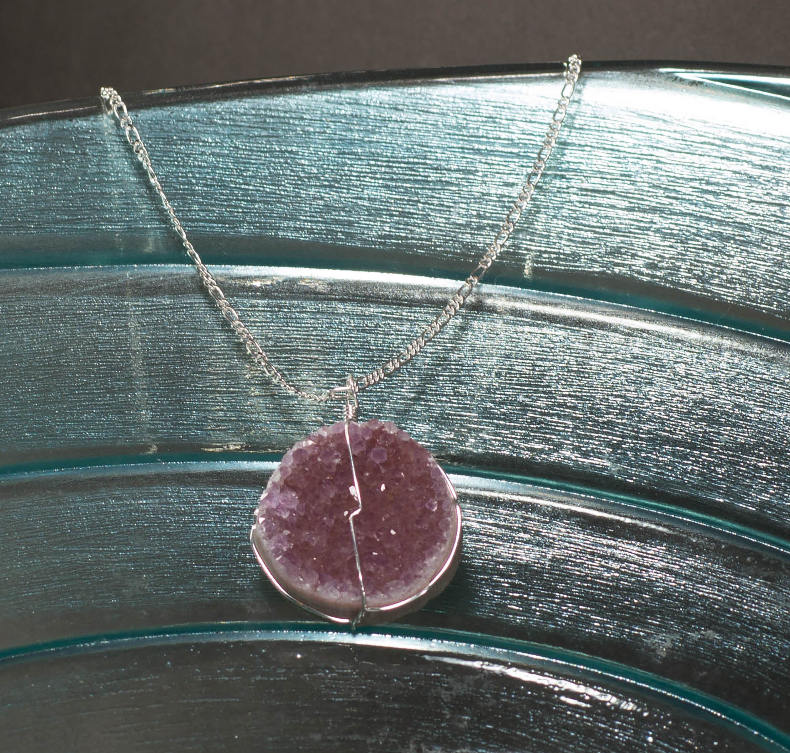 A beautiful druse crystal pendant featuring amethyst, rose amethyst, and citrine crystals, elegantly suspended on a delicate silver chain.