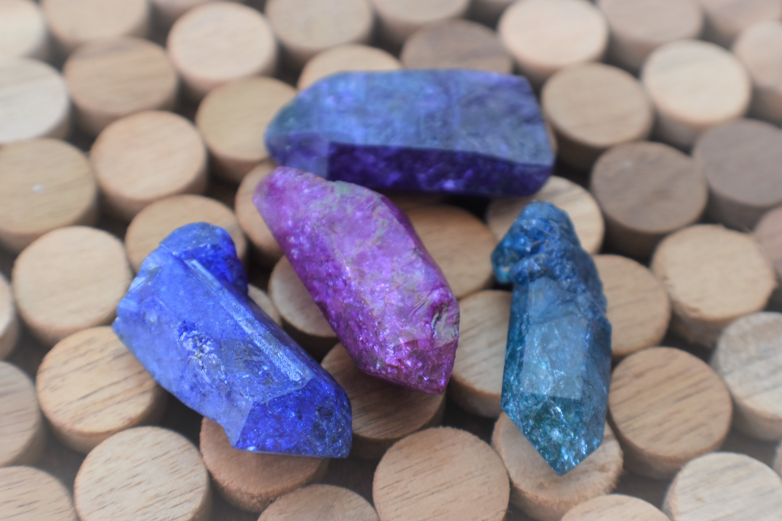 A collection of Dyed Quartz Points in vibrant colors including blue, teal, purple, and pink, showcasing their unique shapes and dazzling appearance.