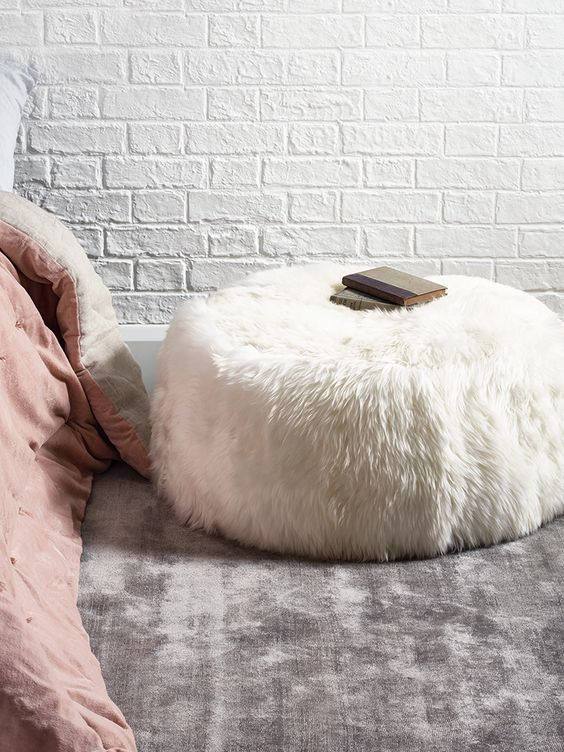 Elegant round pouf made from 100% natural ivory sheepskin with a non-slip leather base, perfect for seating or footrest.