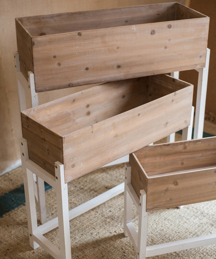 Elevated Wood Planter Box in light brown with a white stand, showcasing three sizes for versatile gardening.