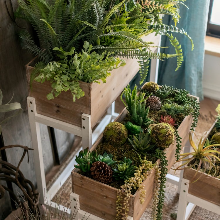 Elevated Wood Planter Box in light brown with a white stand, showcasing three sizes for versatile gardening.