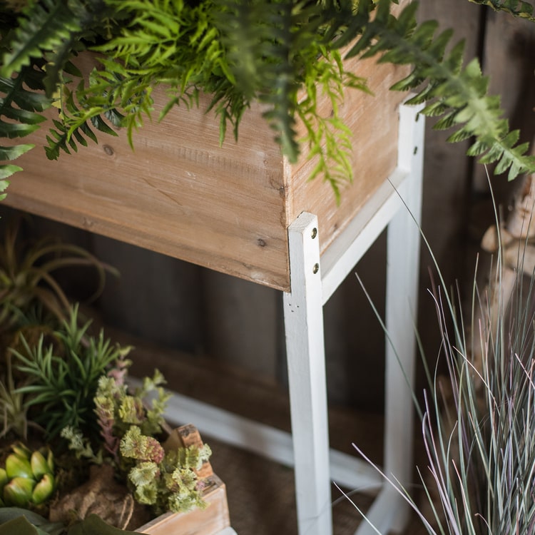 Elevated Wood Planter Box in light brown with a white stand, showcasing three sizes for versatile gardening.